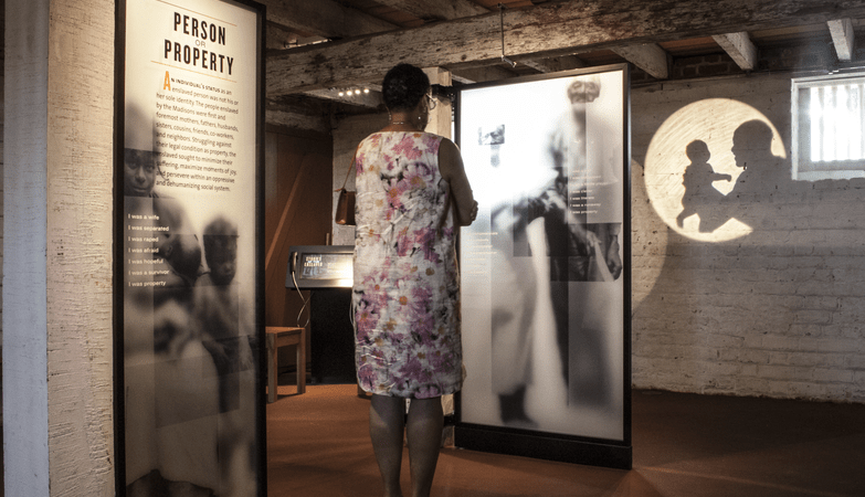 Woman looking at an exhibit describing the history of slavery.