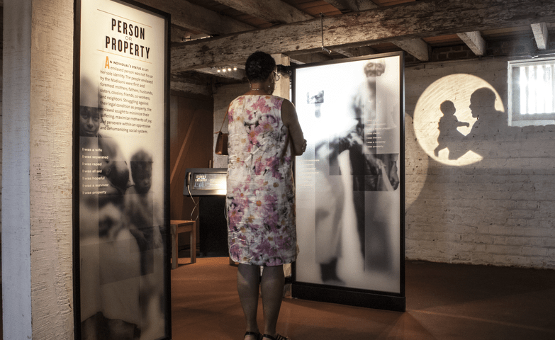Woman looking at an exhibit describing the history of slavery.
