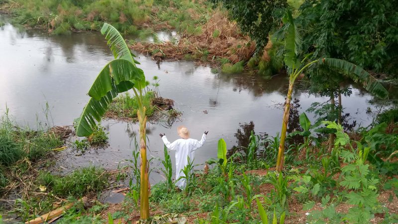 Ugandan heritage projects: The site keeper stands at the rising Nile river waters at Wang-lei