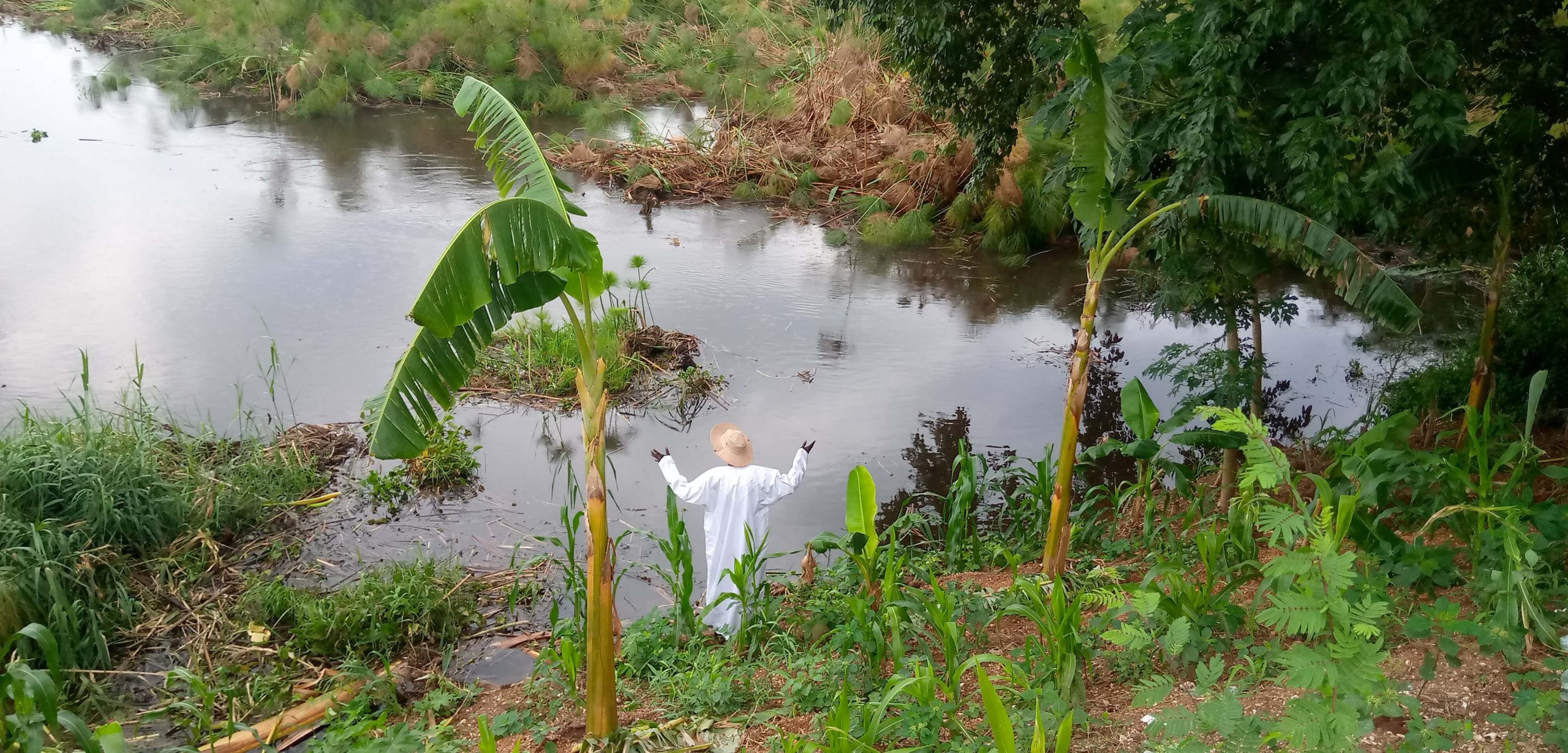 Uganda project: The site keeper stands at the rising Nile river waters at Wang-lei