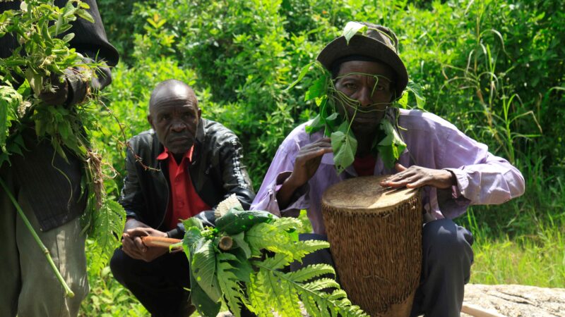 The spiritual leader performs ceremonial drumming at the Enterano confluence to evoke the Bakonzo spirits of the mountain.