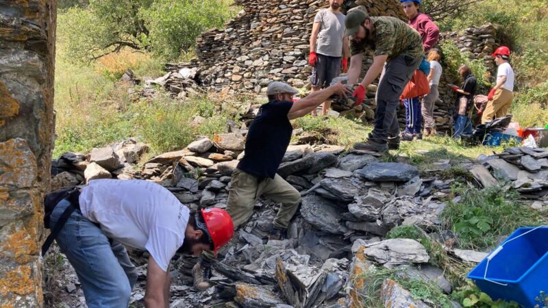 Volunteers work with REMPART expert to recover useable dry stones from tower base for its stabilisation