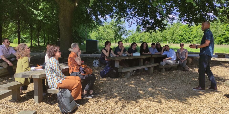 European group members talking in the shade of a tree