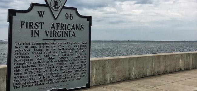 a sign with the words 'first africans in virginia' at Fort Monroe, with the sea in the background