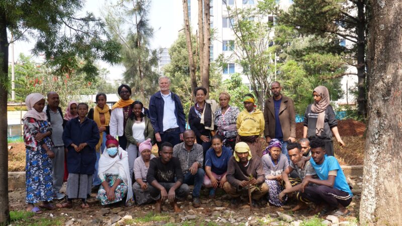 evaluation visit - a large group of people smiling at the camera in a garden in Addis Ababa