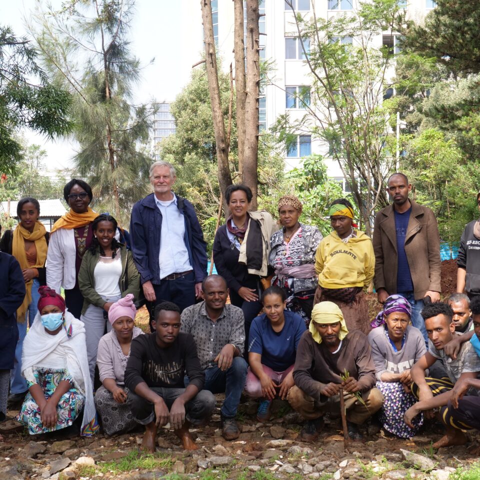 evaluation visit - a large group of people smiling at the camera in a garden in Addis Ababa