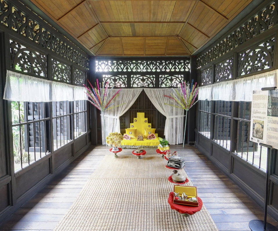 Interior of a traditional house in Malaysia, with ceremonial objects arranged on a rush mat