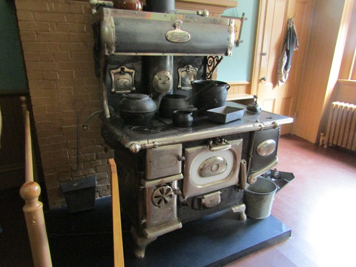 A large cast iron kitchen range with pots and pans arranged on the surface