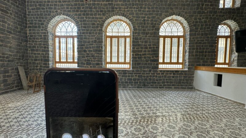 a photo of the interior of a theatre in Homs, Syria with a phone visible in the photo showing the theatre before it was restored with suppport from the Withstanding Change project