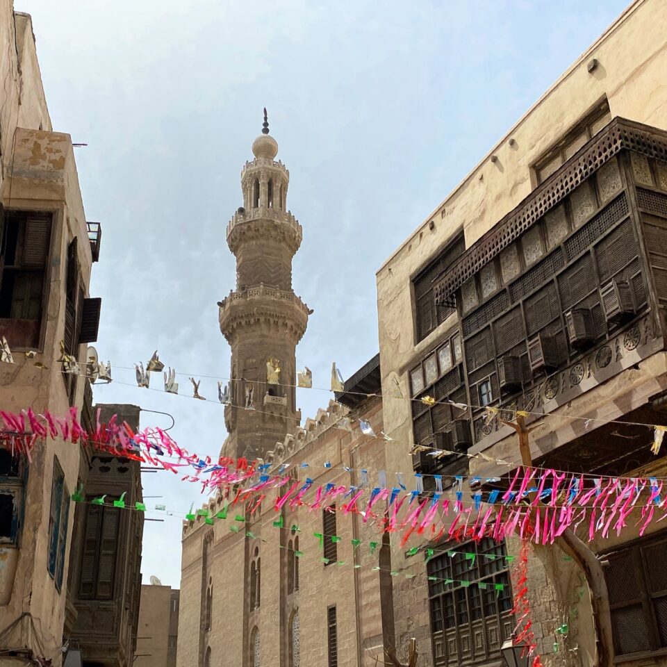 a street in Cairo with pink bunting showing the location of Bayt al Razzaz before it was restored with suppport from the Withstanding Change project