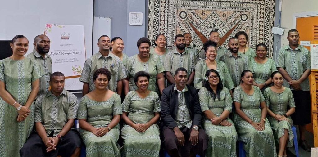 a group of people in traditional Fijian dress, seated facing the camera ranger