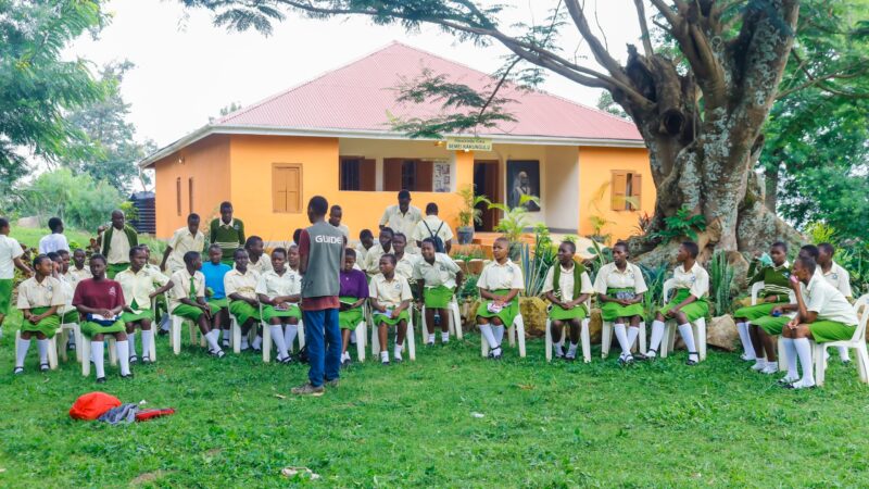 a large group[ of schoolchildren seated in front of the Semei Kankungulu Museum in Uganda