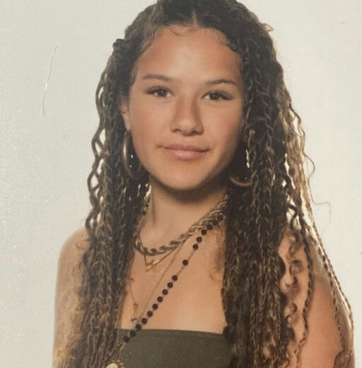 a photo of a young woman with long dark wavy hair