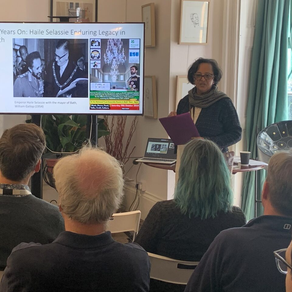 a woman giving a presentation to a room full of people