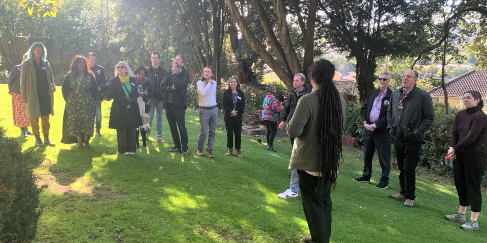 a man speaking to a group of people in a garden