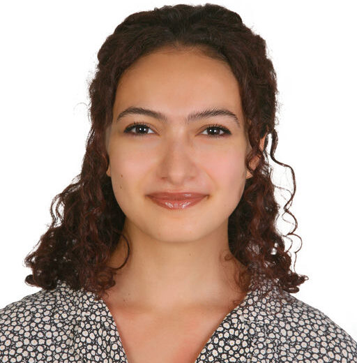 a head shot of a young Jordanian woman with long dark wavy hair