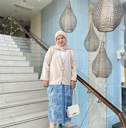 a photo of a young Indonesian woman with a white head scarf and turquoise shoes