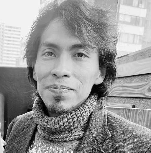 a black and white photo of a young Bolivian man wearing a roll neck sweater and jacket