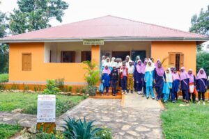 a bright orange building with a group of schoolchildren standing facing the camera