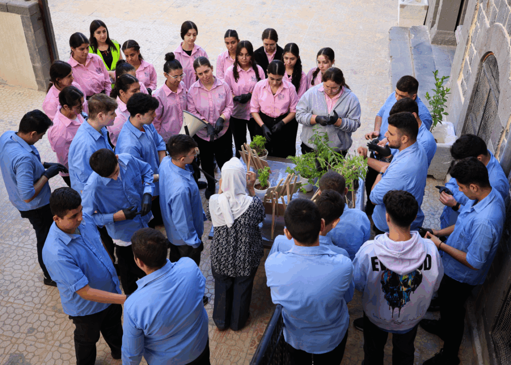 a group of school children taking part in a planting activity