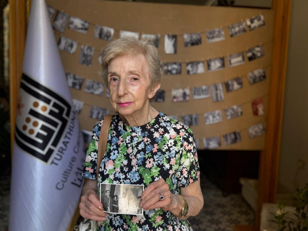 a woman holding an old black and white photo