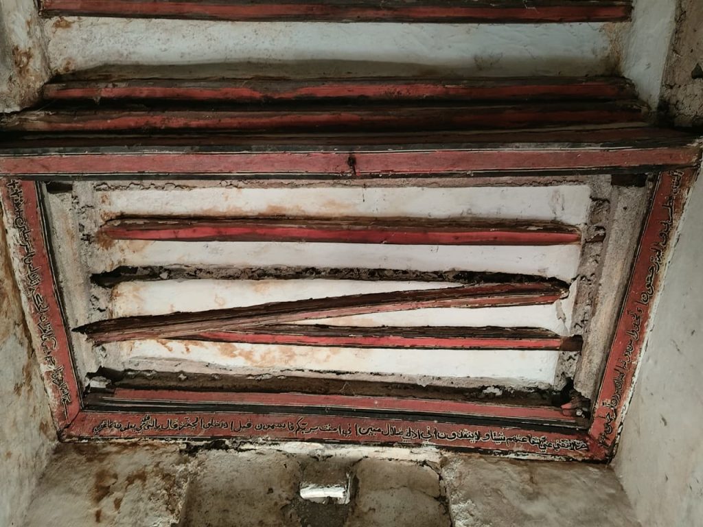 ceiling decoration in the Swaniani Villa, Mutsumudu, Anjouan, Comoros with red timbers and Arabic text on a white background