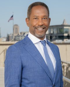 a man in a blue suit smiling at the camera